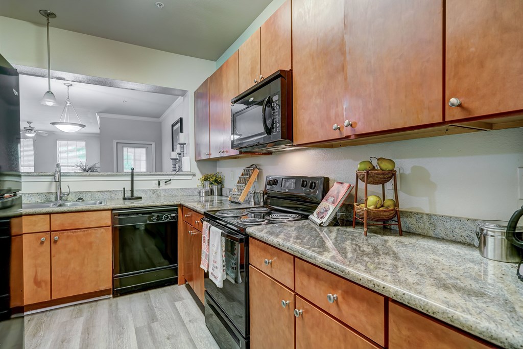 A kitchen with wooden cabinets and a granite countertop.